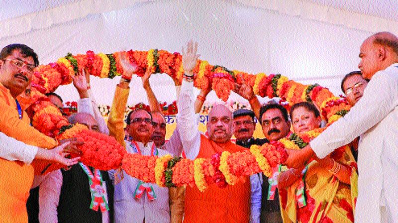 BJP National President Amit Shah being garlanded during Karyakarta Sammelan of Gwalior and Chambal division, in Shivpuri, Tuesday. (Photo: AP)