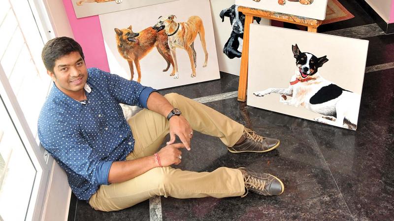 Chakra, the artist poses with his pooch paintings