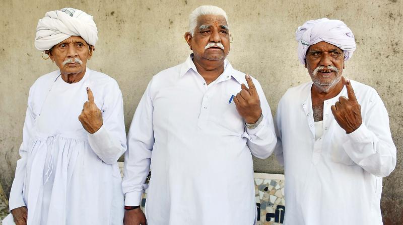 Voters show their inked fingers at a polling booth during Gujarat Assembly election, in Surat on Saturday 	(Photo: PTI)