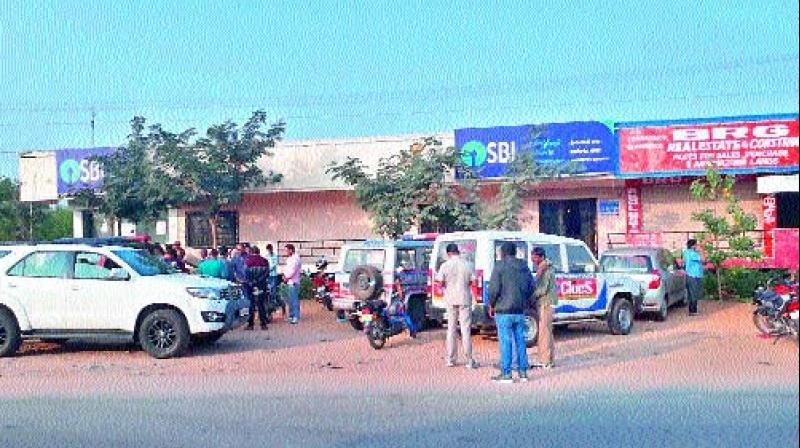 Police vans lined up outside the SBI Shameerpet branch on Sunday. (Photo: DC)