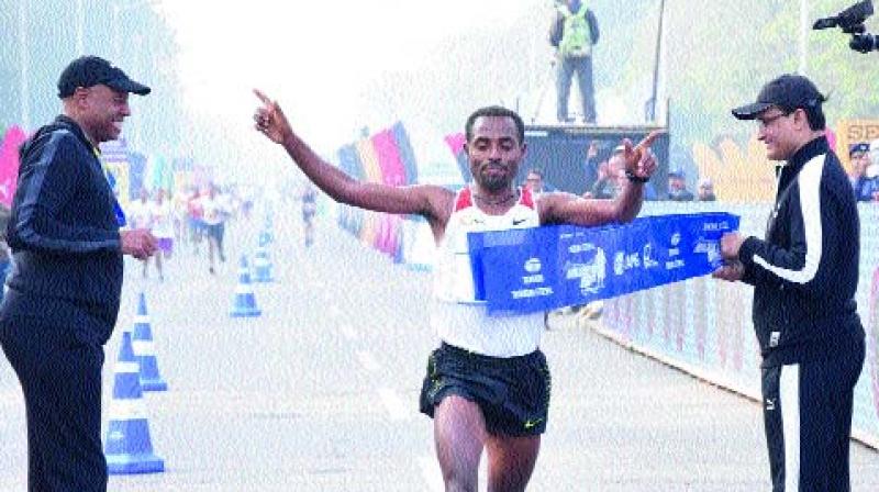 Kenenisa Bekele (centre) crosses the finish line to win the international overall elite mens title at the Kolkata 25K race on Sunday.