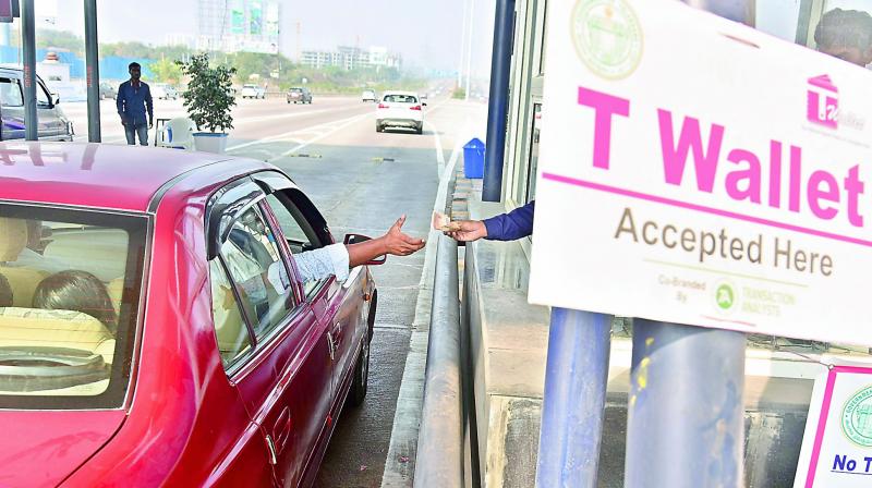A motorist pays cash at a toll plaza on the Outer Ring Road, where the electronic toll management system has stopped working. (Photo: R. Pavan)