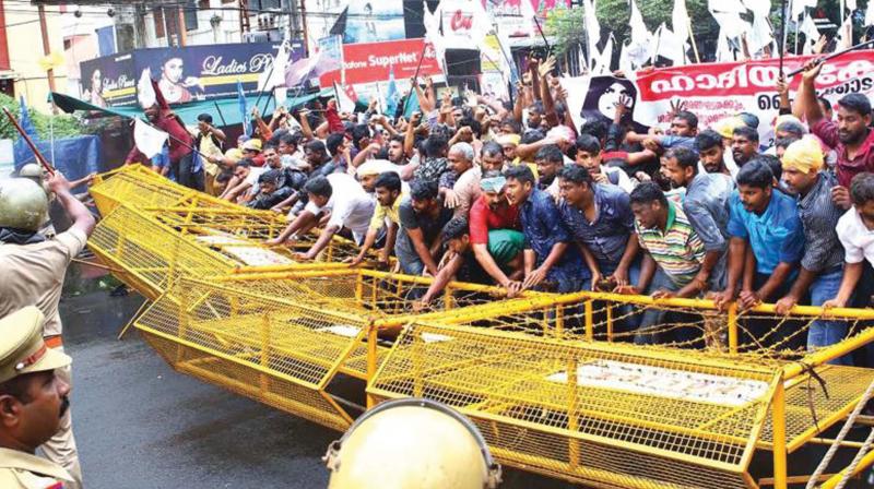 Muslim Co-ordination Committee supporters wrestle with police barricades during a march to the High Court in Kochi to protest against the verdict in Hadiya case. (Photo: DC File)