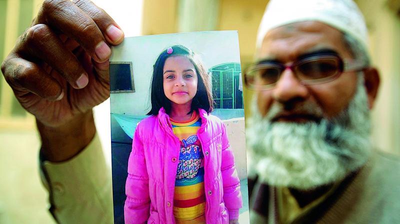 Mohammed Amin shows a picture of his seven year-old daughter, Zainab Ansari in Kasur, Pakistan. (Photo:AP)