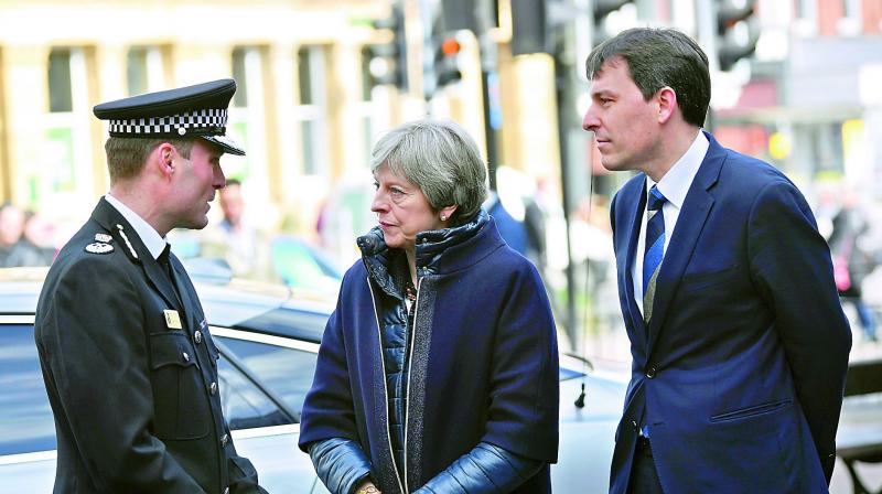 Britains Prime Minister Theresa May being briefed by members of the police at the place where former Russian double agent Sergei Skripal and his daughter were found critically ill, in Salisbury, England on Thursday. (Photo:AP)
