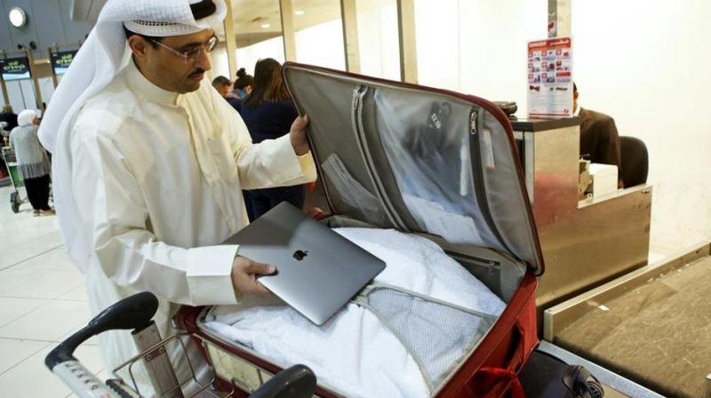 Kuwaiti social media activist Thamer al-Dakheel Bourashed puts his laptop inside his suitcase at Kuwait International Airport in Kuwait City before boarding a flight to the United States on March 23, 2017. (Photo: AFP)