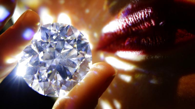 A 102.34, carat, D colour and flawless white diamond held by a model is displayed at Sothebys auction house in London. (Photo: AP)