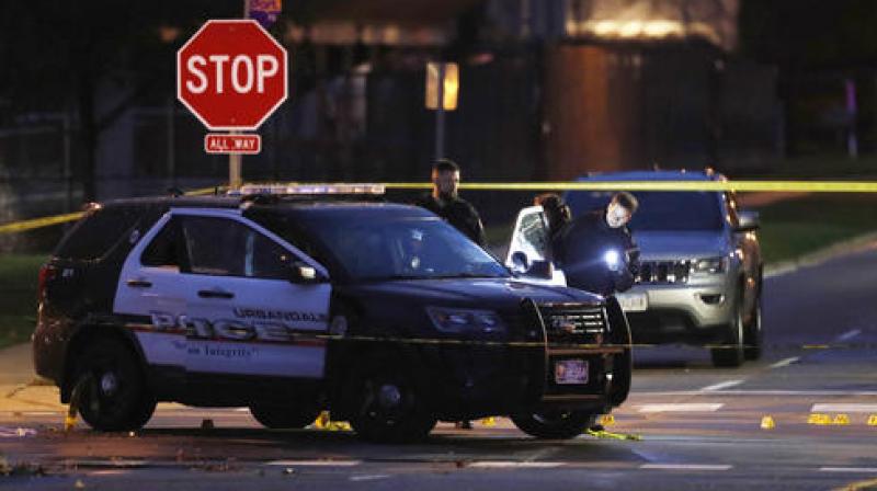 Police officers gather evidence at the scene of the shooting. (Photo: AP)
