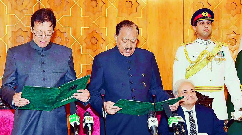 President of Pakistan Mamnoon Hussain (center) takes an oath from newly-appointed Prime Minister Imran Khan (left) during a ceremony in Islamabad, as caretaker Prime Minister of Pakistan Nasirul Mulk (second right) looks on. (Photo: AFP)
