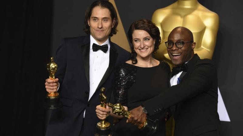 Jeremy Kleiner, from left, Adele Romanski and Barry Jenkins, winners of the award for best picture for \Moonlight\, pose in the press room at the Oscars. (Photo: AP)