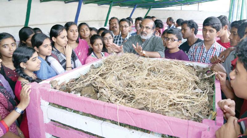 Finance minister Thomas Isaac explains to students on aerobic bins. (File pic)
