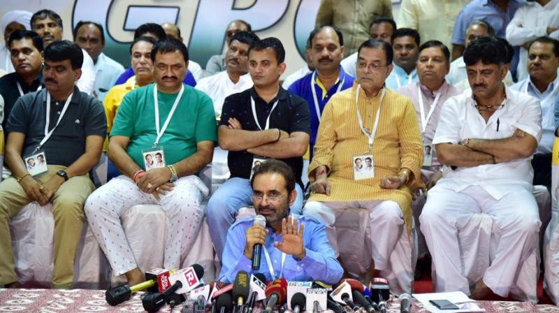 Congress spokesperson Shakti Singh Gohil speaks as Gujarat Congress MLAs seen behind him during a press conference at a resort on the outskirts of Bengaluru on Sunday. (Photo: PTI)