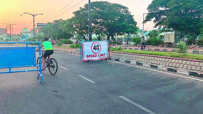 A cyclist pedals his way through one of the barricades put up at Sanjeevaiah Park in Hyderabad on Saturday. Ten such barricades have been put up on this stretch. The speed limit for all vehicles taking the Necklace road has been fixed at 40 km per hour.
