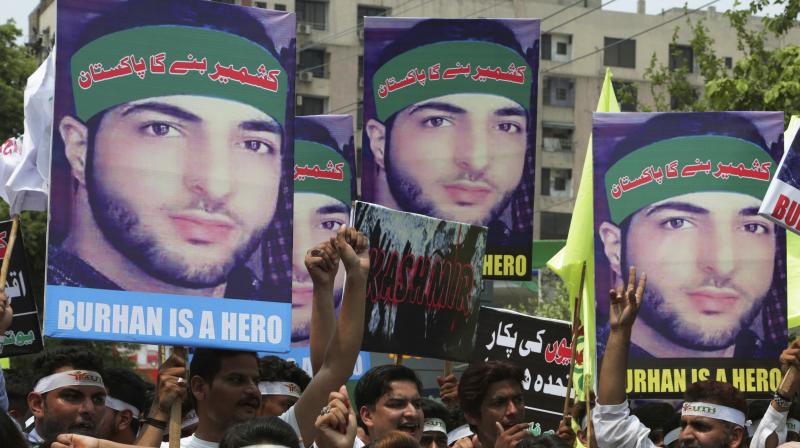 Burhan Wani was responsible for several attacks against security personnel in J&K. In picture: Members of the non-governmental organisation hold posters of Wani during a rally to in Lahore, Pakistan. (Credit: PTI)