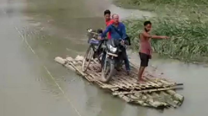 As heavy rainfall in Bhutan leads to rise in water levels of Pagladia and Borolia rivers washing away a bridge in Tamulpur & obstructing Tamulpurs connection to Baksa District Headquarters. (Photo: ANI)