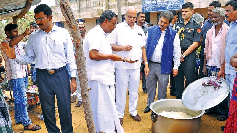 Governor Banwarilal Purohit and minister for handlooms and textiles O.S.Manian inspect rice cooked at a camp in Nagapattinam on Wednesday. (Photo: DC)