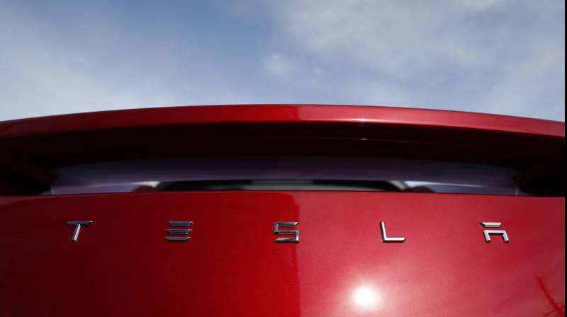 The sun shines off the rear deck of a roadster on a Tesla dealers lot in the south Denver suburb of Littleton, Colo. (AP Photo/David Zalubowski, File)