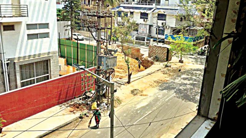 A pourakarmika seen dumping all the garbage and leaves under a transformer on 13th A Main Indiranagar. (Photo: DC)