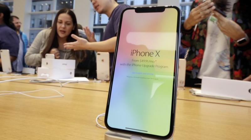 Customers buy the iPhone X at the Apple Store on New Yorks Fifth Avenue. Apple is expected to unveil its biggest and most expensive iPhone on Wednesday, Sept. 12, 2018, as part of a lineup of three new models aimed at widening the products appeal amid slowing sales growth. (AP Photo/Richard Drew, File)