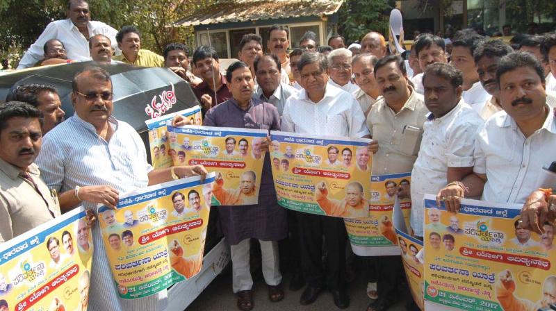 BJP leaders Jagadish Shettar and Pralhad Joshi release stickers of partys December 21 Parivarthana Yatra, in Hubballi on Monday. (Photo: DC)