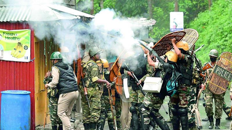 Security personnel fire tear gas during a protest by Gorkha Janmukti Morcha activists in Darjeeling on Saturday. (Photo: PTI)