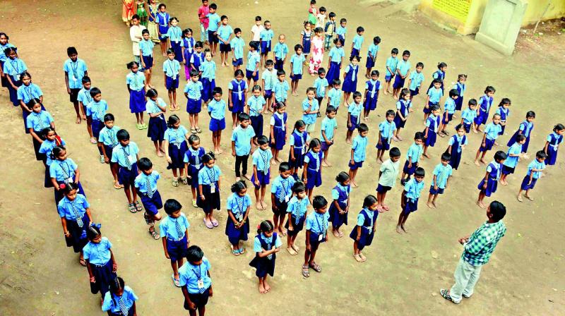 J. Krishna, the only teacher at the Velagapudi Lakshman Datt Municipal Corporation School in Vijayawada, administers the pledge to students at the start of the school day, on Monday. (Photo: Deccan chronicle)