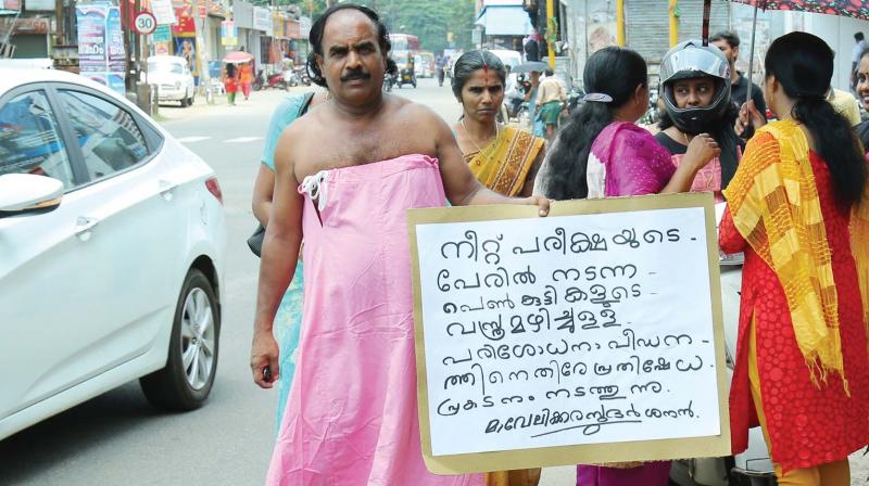 Mavelikara Sudarasanan, a social activist, carries out a solo protest against the recent frisking incident at NEET centre, wearing a sari petticoat at Michel Junction Mavelikara on Tuesday. (Photo: BY ARRANGEMENT)