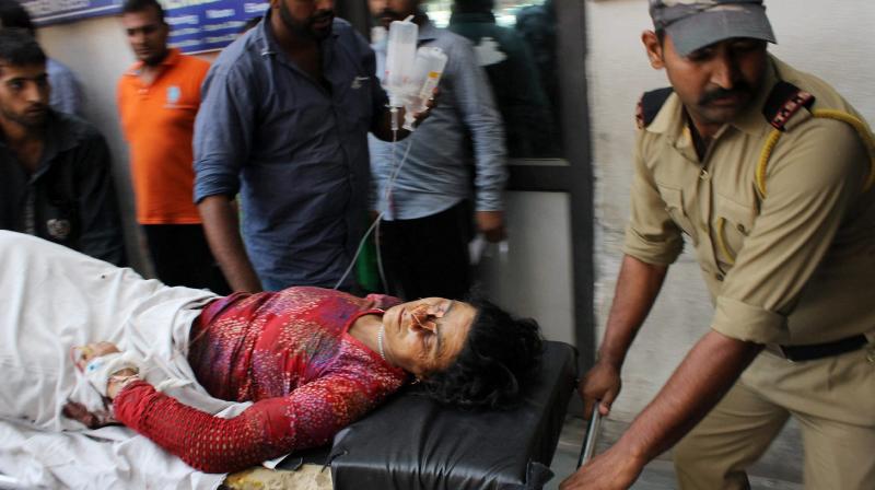A security personnel taking a civilian to a GMC hospital in Jammu after she was injured in cross-border firing by Pakistan. (Photo: PTI)