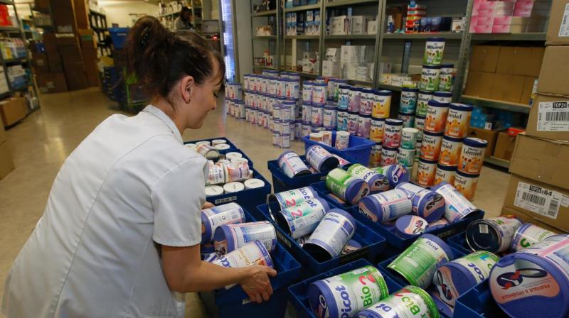 A drugstore employee removes baby milk boxes from the stock in Anglet, southwestern France. Photo:AP