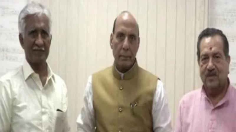 Union Defence Minister Rajnath Singh met Airman C B R Prasad on Monday and received the cheque from him. (Photo: ANI)