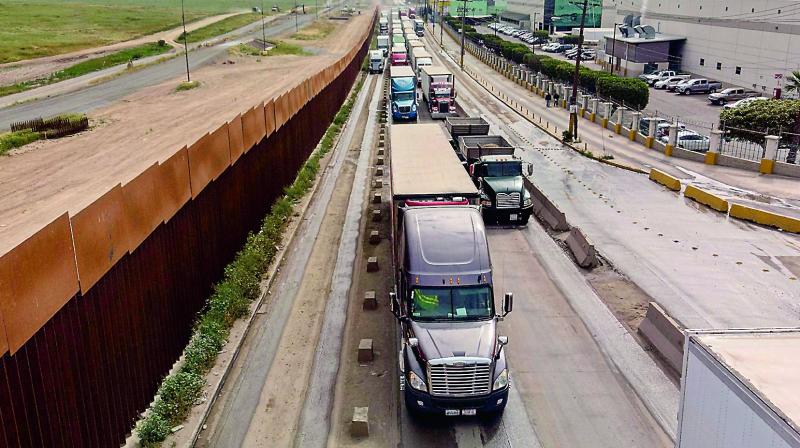 An April 4 picture shows cargo trucks lined up to cross to the US near the US-Mexico border at Otay Mesa crossing port in Tijuana, Baja California state, Mexico. 	( AFP