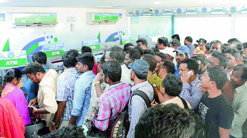 People in large numbers throng an ATM kiosk in Rednamgardens SBI Branch in Visakhapatnam, to withdraw money.