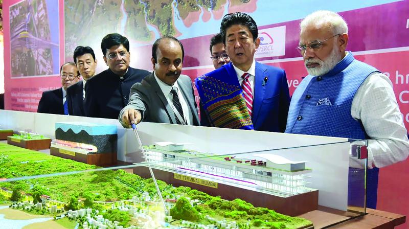 Prime Minister Narendra Modi (L) and Japanese Prime Minister Shinzo Abe look at a railway station model at a ground-breaking ceremony for the Mumbai-Ahmedabad high speed rail project in Ahmedabad on Thursday. (Photo: AFP)