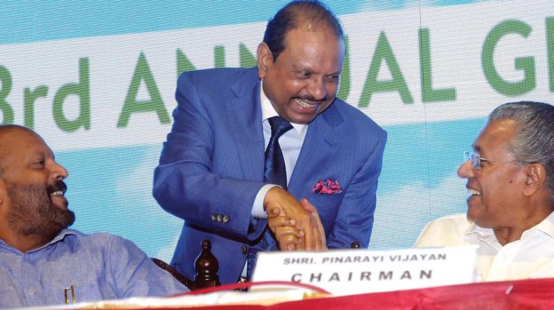 Chief minister Pinarayi Vijayan greets CIAL director and NRI businessman Yusuff Ali M.A. during the  CIAL annual general meeting in Kochi on Monday. Agricultural  minister V.S. Sunil Kumar looks on. (Photo: ARUNCHANDRA BOSE)