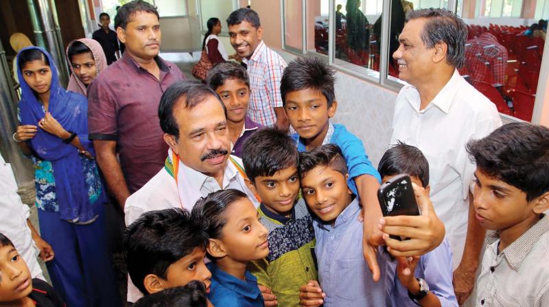 UDF candidate K. N. A. Khader poses for a groupie with children during a campaign at Othukkungal on Saturday. (Photo: DC)