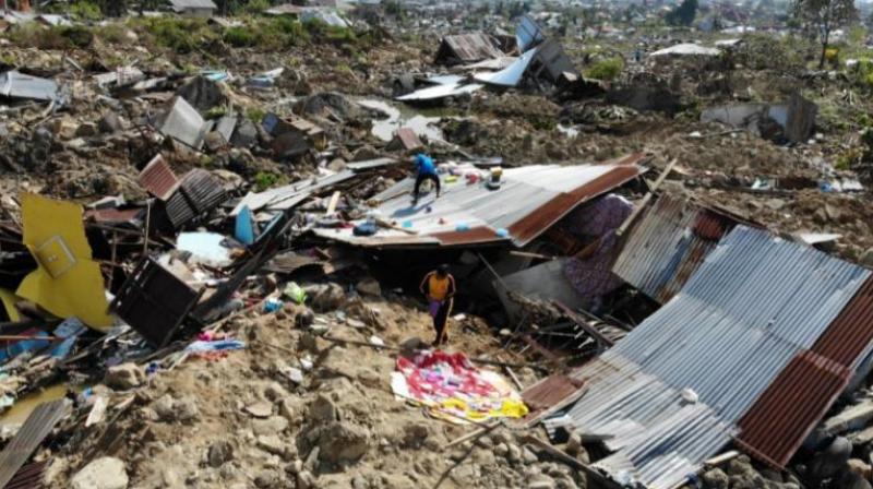 Quake-tsunami survivors salvage useable items from the debris homes that were destroyed in Palu, Indonesia on Friday. (Photo: Twitter | @AFP)