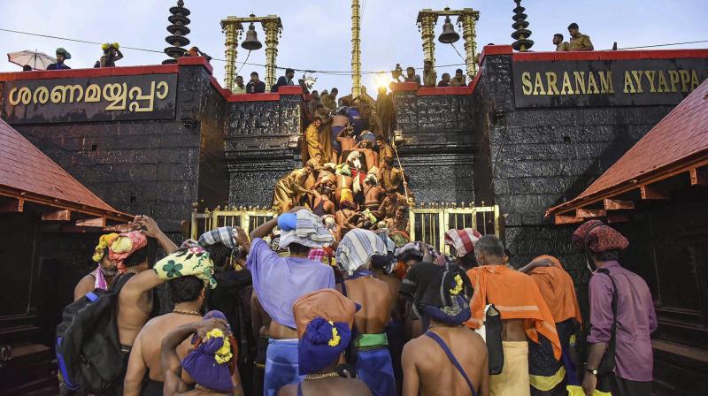 Devotees enter the Sabarimala temple as it opens amid tight security on Friday. (Photo: PTI)