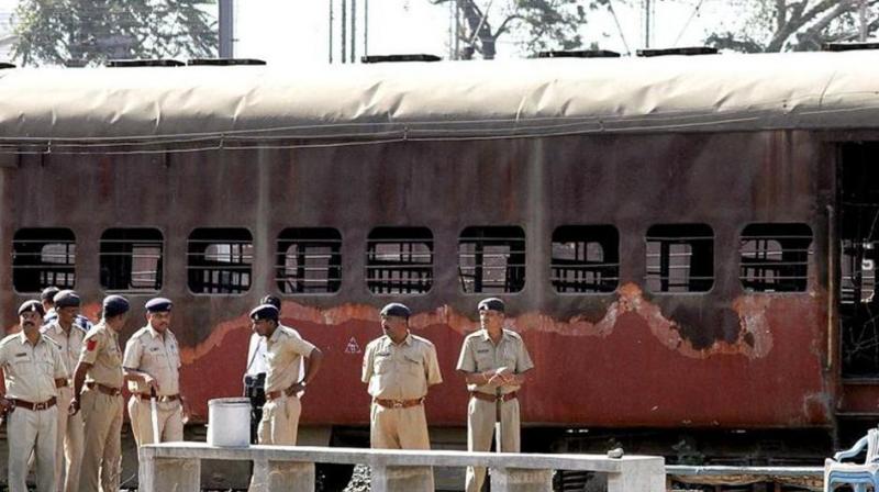 Cops stand guard in front of Sabarmati Express at Godhra station. (Photo: PTI)