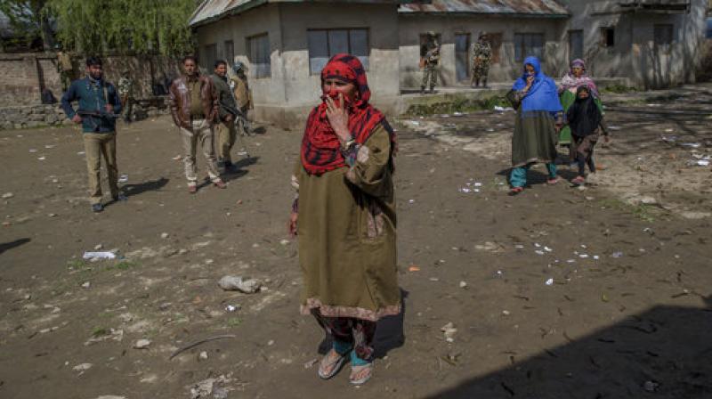 Kashmiri women hide their faces from cameras to conceal their identity as they arrive to cast their votes during a re-polling of a by-election for a vacant seat in Dooniwari. (Photo: AP)