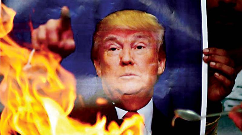 Protestors burning a picture of of US President Donald Trump.