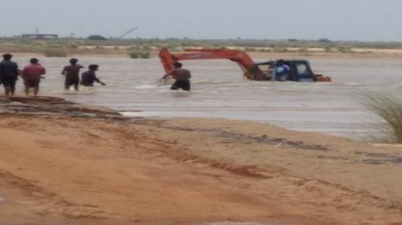 The driver was engaged in work when all of a sudden the water level in Godavari increased and the machine submerged into the river.  (Photo; ANI /Representational)