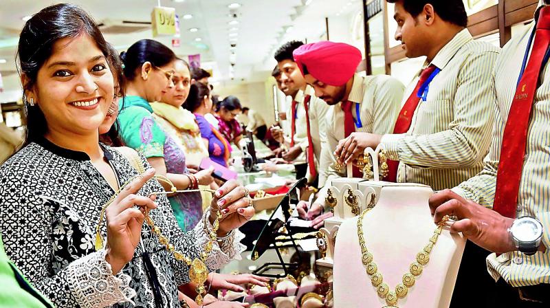 A woman tries a gold necklace in a shop on the occasion of Akshaya Tritiya in New Delhi on Friday.(Photo: PTI)