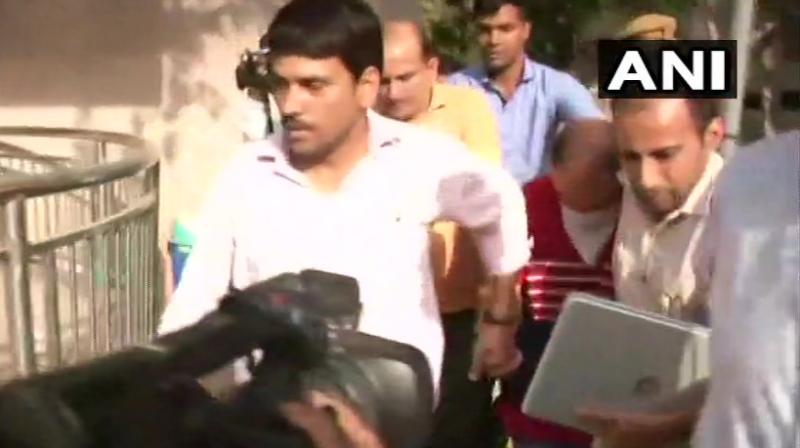 Major Nikhil Handa (in red) was brought to the Punjabi Bagh police station from Meerut on Sunday. (Photo: ANI/Twitter)