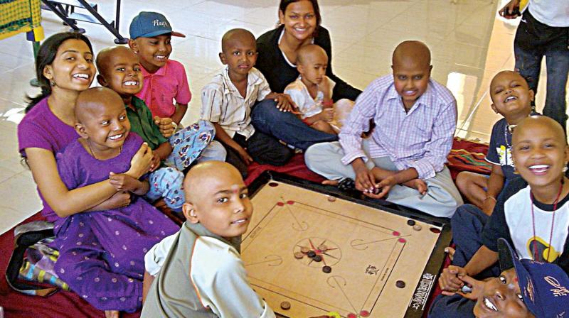 A file photo of volunteers of an NGO with children under treatment for cancer.