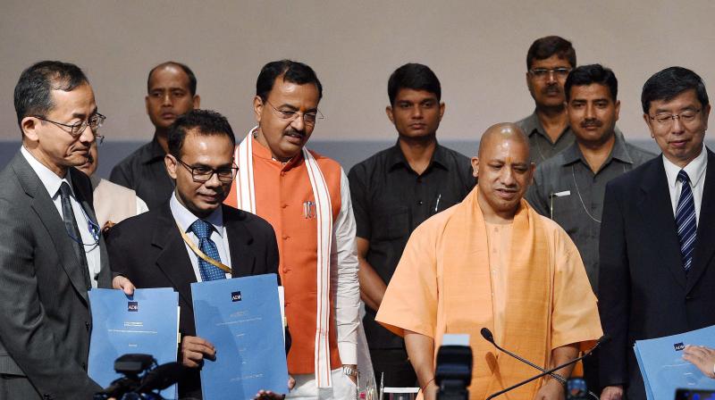 Uttar Pradesh Chief Minister Yogi Aditiyanath with Takehiko Nakao, President Asian Development Bank after signing up of agreement between U P Government and ADB at Lok Bhawan in Lucknow on Tuesday. UP Deputy Chief Minister Keshav Prasad Maurya is also seen. (Photo: PTI)