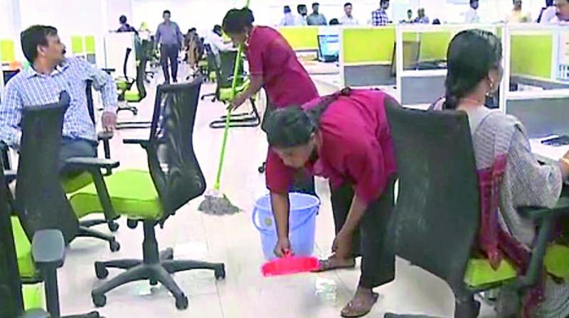 Rainwater being baled out by sanitation staff in the first floor of the AP Temporary Secretariat at Velagapudi of AP capital region on Tuesday. (Photo: DC)
