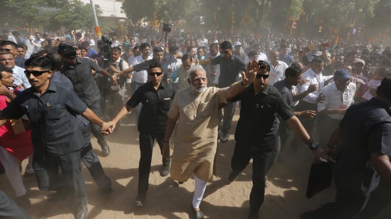 Indian Prime Minister Narendra Modi, center, waves as he leaves after visiting a school he studied, during his visit to his hometown Vadnagar, India. (Photo: AP)