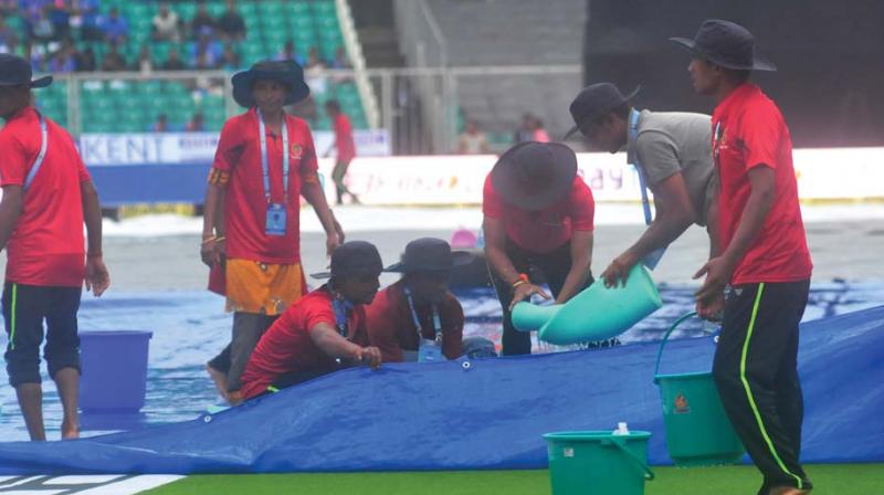 Grounds-keeping team in action during the rain-soaked T-20 match between India and New Zealand held at Greenfield stadium, Thiruvananthapuram, on Tuesday. (Photo: DC)