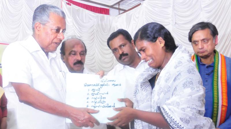Chief minister Pinarayi Vijayan hands over financial aid to Sunitha M., wife of Jayan who died in Ockhi disaster, in Thiruvananthapuram on Monday. Revenue minister E. Chandrasekharan and Shashi Tharoor, MP, look on. (Photo: A.V. MUZAFAR)