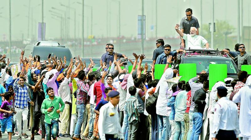 Prime Minister Narendra Modi waves during the roadshow, after inaugurating the 9-km long section of Delhi-Meerut expressway, in East Delhi, on Sunday. 	(Photo: PTI)